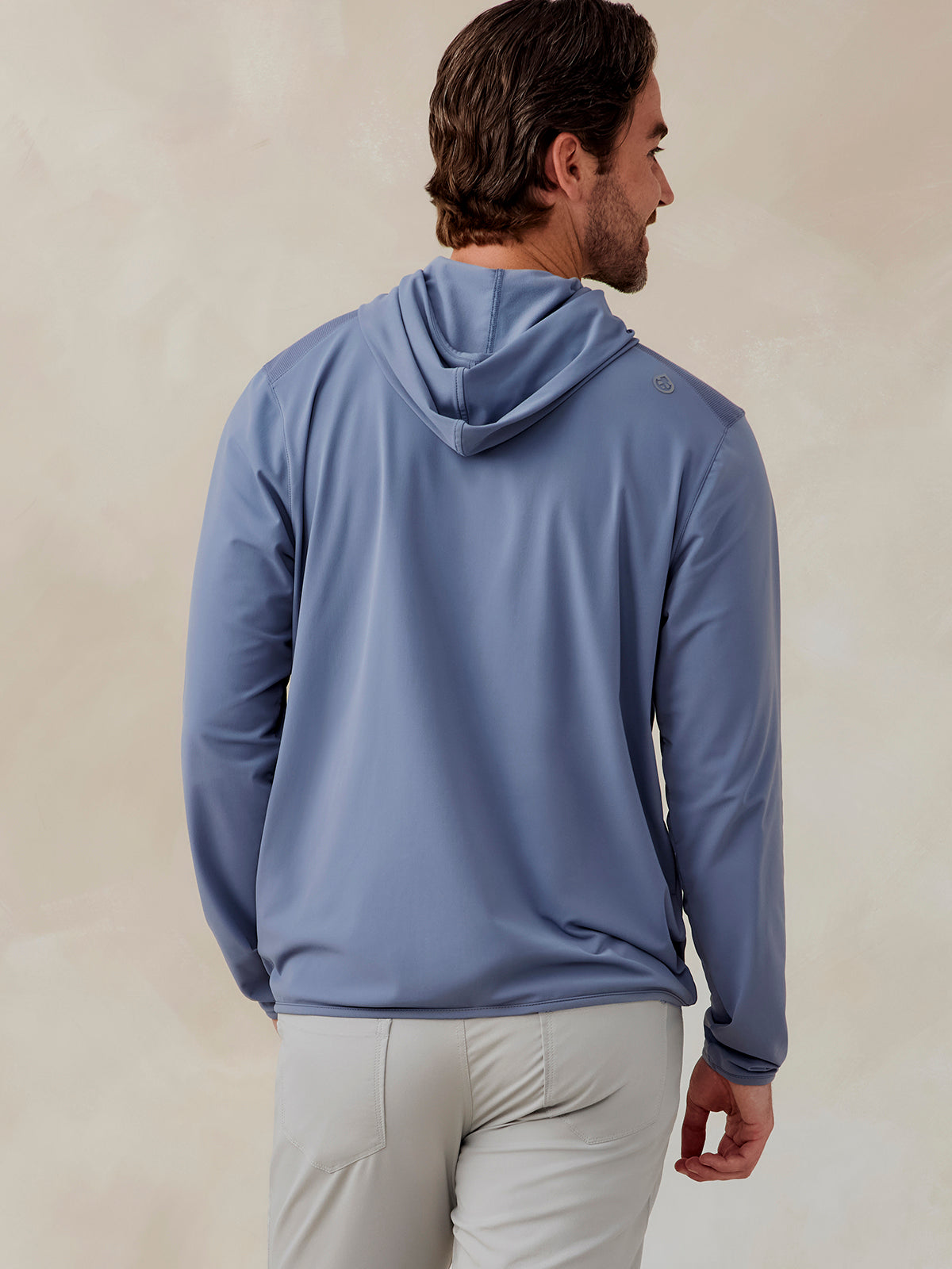 Man wearing a light blue Stratford hoodie with a hood and long sleeves, shown from the back in a casual pose tasc Performance Stratford Hoodie (Anchor)