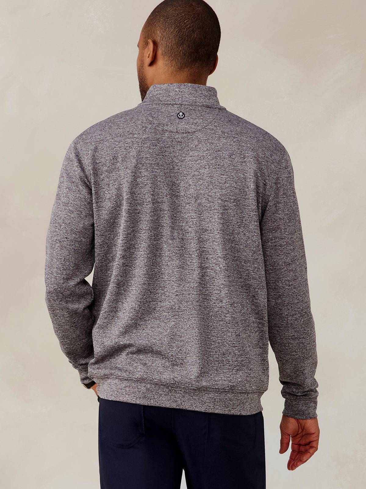 Man wearing a heathered gray Crest Jacquard quarter zip pullover shown from the back with long sleeves and a stand collar tasc Crest Jacquard Quarter Zip (Charcoal)