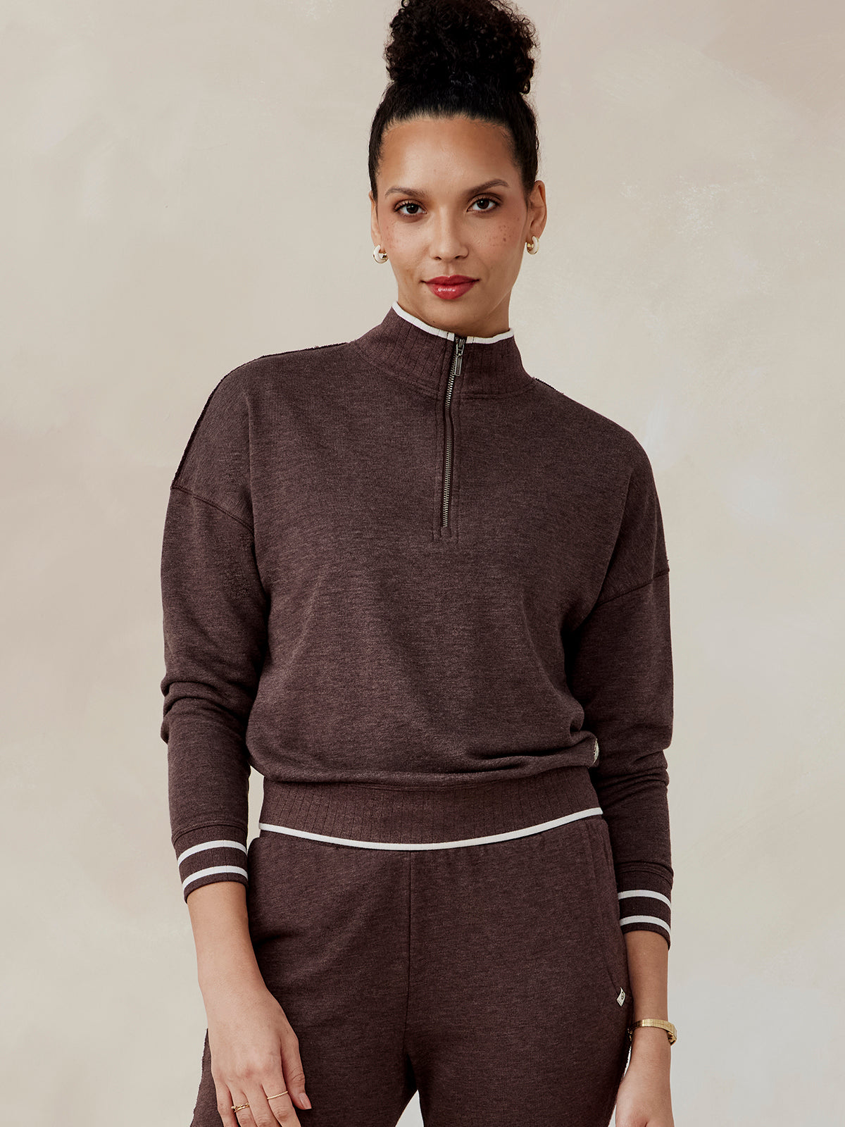 Woman wearing a brown Stadium French Terry half zip pullover with white trim on collar, cuffs, and waistband, front view tasc Stadium French Terry Half Zip (MochaHeather)