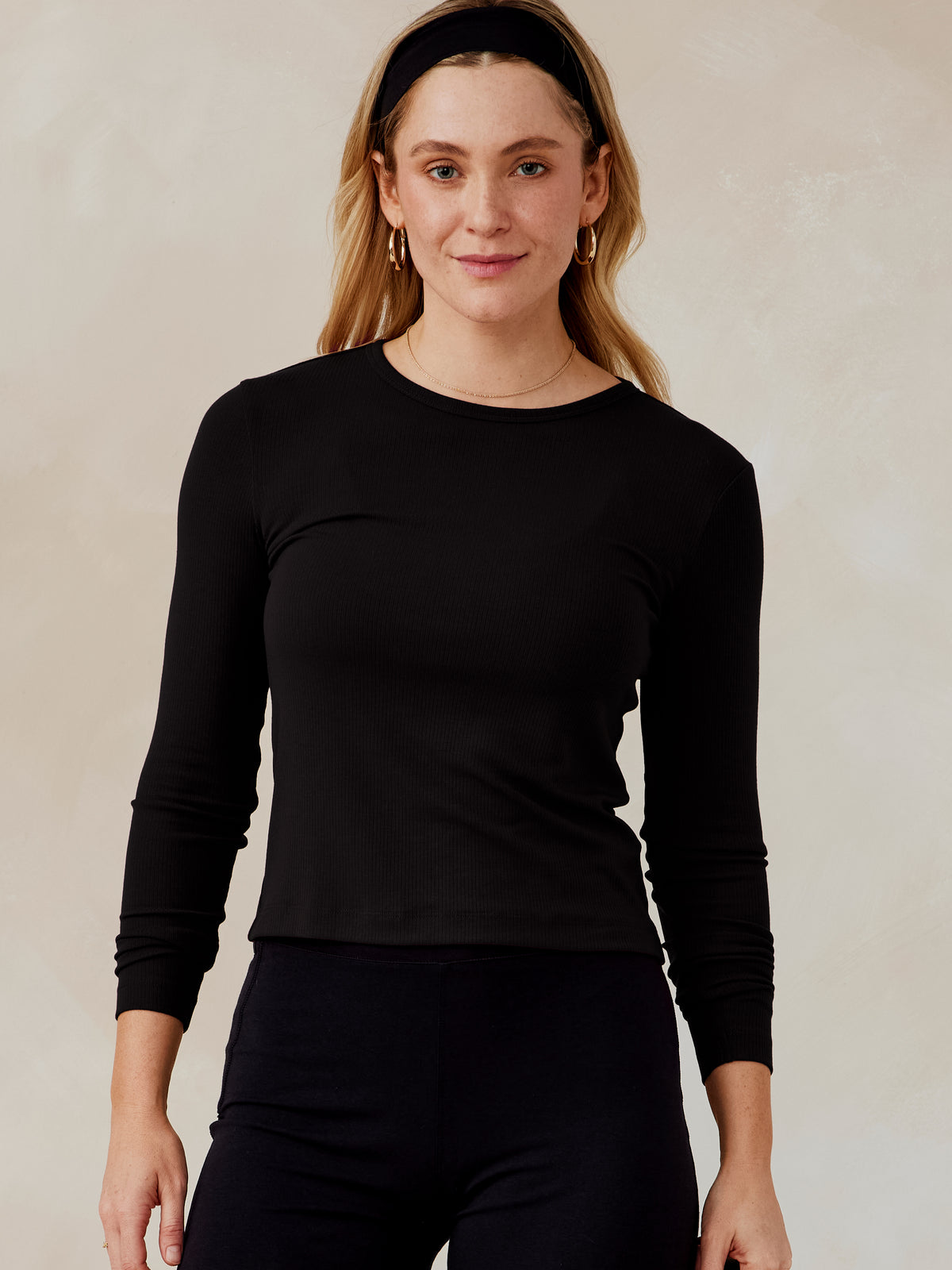 Woman wearing a black Microluxe ribbed long sleeve top with crew neckline, paired with black pants, front view tasc Microluxe Rib LS (Black)