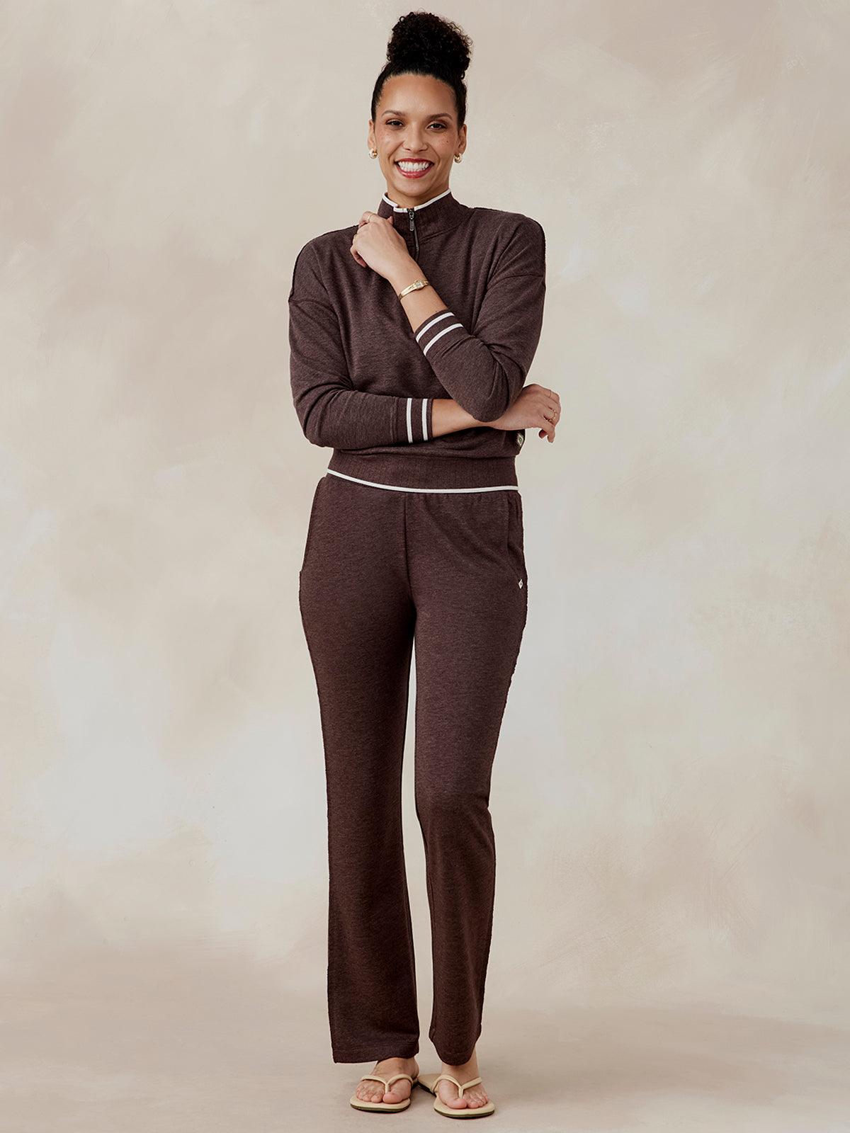 Woman wearing a brown Stadium French Terry half zip with white stripe details on cuffs and waistband, paired with matching pants tasc Stadium French Terry Half Zip (MochaHeather)