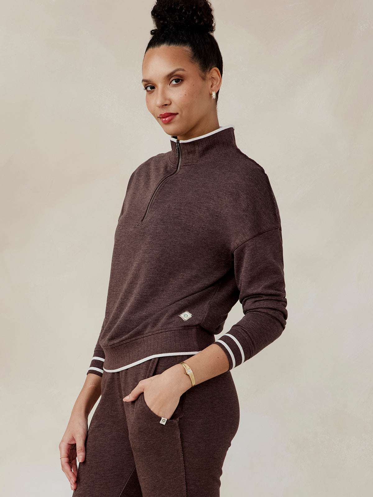 Woman wearing a brown Stadium French Terry half zip pullover with white trim and ribbed collar, cuffs, and hem, side view tasc Stadium French Terry Half Zip (MochaHeather)