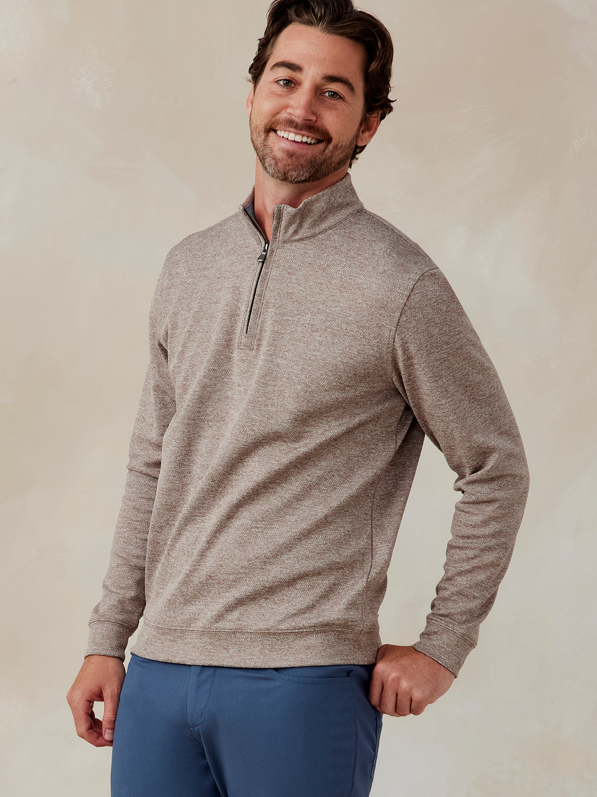 Man wearing a light brown jacquard quarter-zip pullover with a stand collar and blue pants, front view tasc Crest Jacquard Quarter Zip (Tan)